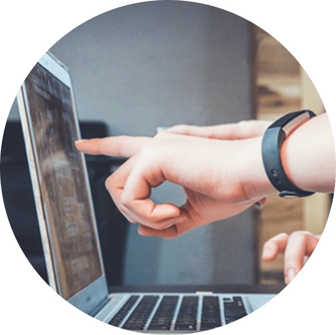 Hand pointing at laptop screen